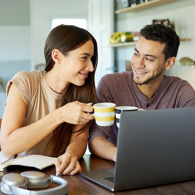 couple drinking coffee on laptop