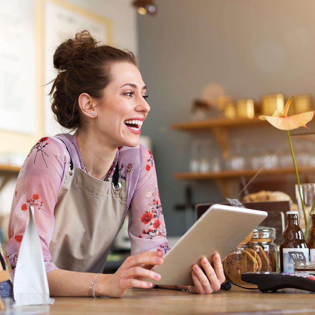 woman business owner using tablet at store